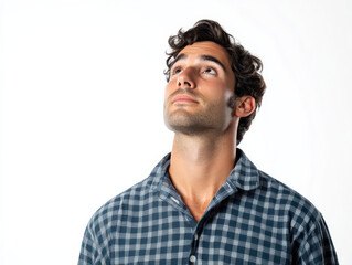 Obraz premium Looking up thoughtfully, man in checkered shirt expresses curiosity