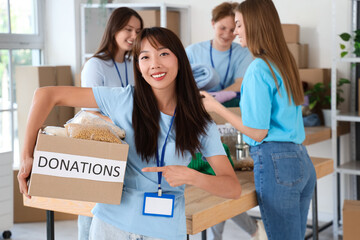 Young female volunteer with donations for poor people in center