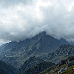 A rugged mountain range with dark gray clouds looming in the background, rugged, gray, dark
