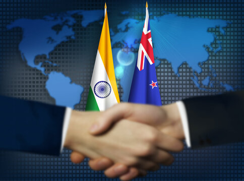 Two person shaking hands in front New Zealand and Indian flags
