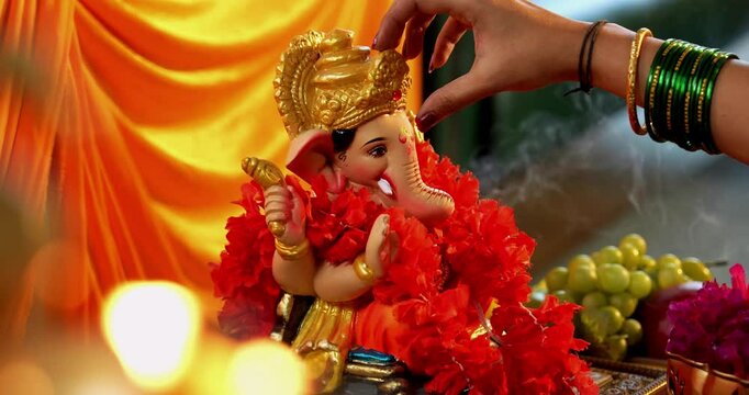 Closeup of Beautiful Clay Ganesh Idol Being Worshipped by a Hindu Woman with Puja Thali During Ganesh Chaturthi Festival