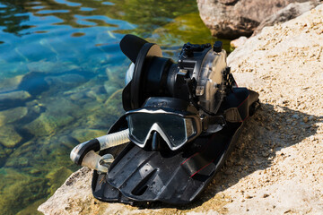 Underwater photography gear. Mirrorless camera in a waterproof protective case, snorkel with mask...