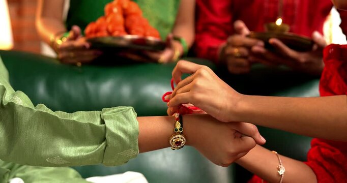 Rakshabandhan Festival - Closeup of Small Girl's Hand Tying Rakhi to Brother's Wrist, Celebrating the Sacred Bond of Sibling Love in India
