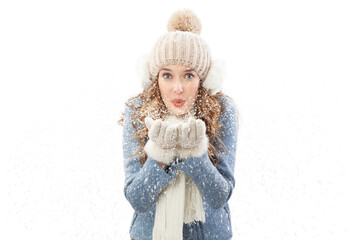 Happy young woman blowing snow from her hands looking into the camera, isolated on white background. A vacation in the Christmas holidays in winter season. Concept of cooling and heating temperatures