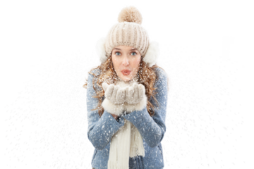 Happy young woman blowing snow from her hands looking into the camera, isolated on white background. A vacation in the Christmas holidays in winter season. Concept of cooling and heating temperatures