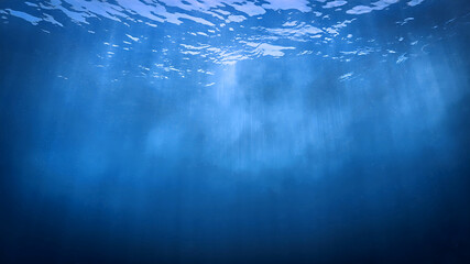 Underwater photo of rays of sunlight coming through the surface of the blue ocean. From a scuba dive - Unspecified.