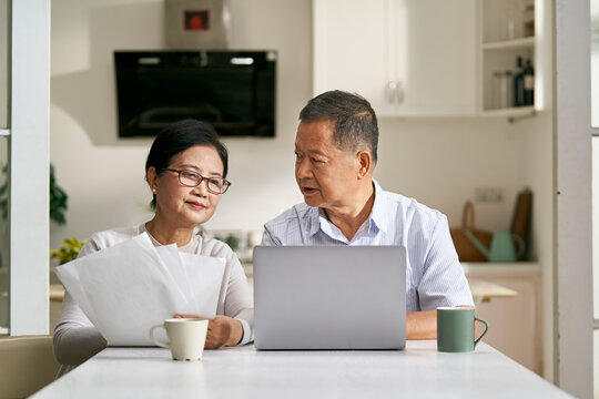 senior asian couple making financial plan using laptop computer