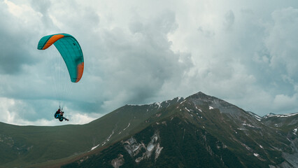 People paragliding between the mountains of Kazbegi.