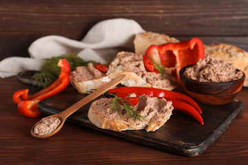 Board with toasts, tasty pate, dill and chilli peppers on wooden background