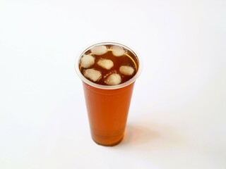 A refreshing iced tea served in a convenient plastic cup. A classic iced tea, served in a disposable clear plastic cup. Indonesia classic beverage