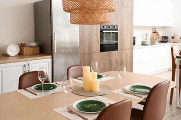 Romantic candles on served table in modern kitchen