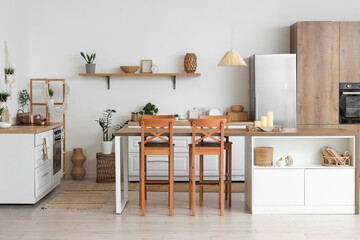 Interior of modern kitchen with candles on tray on table