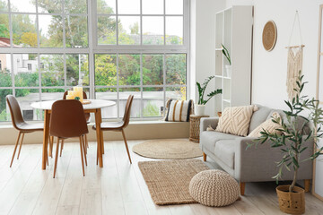 Interior of stylish living room with comfortable sofa and dining table