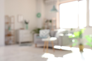 Cozy sofa and coffee table in interior of living room. Blurred view