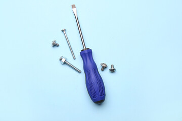 Screwdriver with tap bolts on blue background