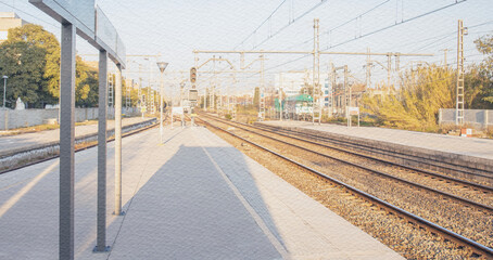 Train station with a few people waiting on the platform