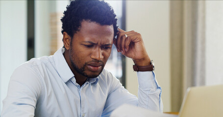 Confused, documents and laptop with business black man in home office for financial audit or...