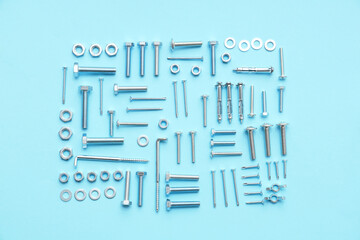 Arrangement of different tap bolts, chrome nuts and hex keys on blue background