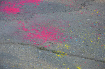 Bright colored spots of powder paint on the asphalt.