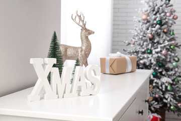 Word XMAS with decor on commode in room, closeup