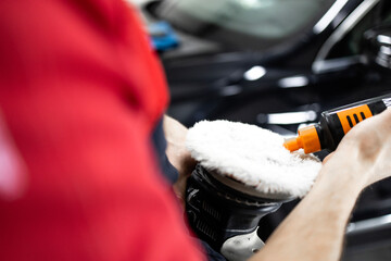 Car body paint work. Close up view of adding polishing paste to the brush.