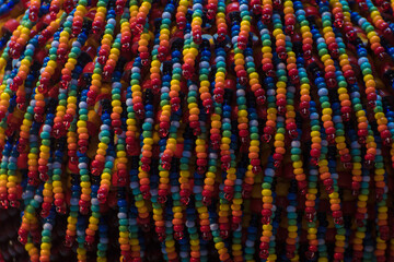 Dettaglio di alcune perline di plastica di tutti k colori legate insieme © Andrea Vismara
