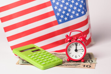 Time to Pay Bills. US flag, American Dollars and Calculator, Red Alarm clock