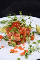 Avocado tartare with salmon, red caviar and pea sprouts.