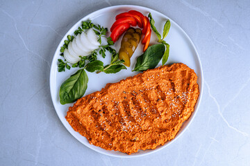 Plate of Omelet with Fresh Vegetables, Top view of a dish featuring Omelet garnished with sesame seeds, accompanied by fresh vegetables like onions, peppers, and greens.