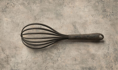 Vintage Rustic Metal Whisk on Textured Grey Background
