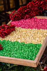 Tricolore Italian flag made with raw pasta ingredient in shelves and red spicy peppers in a food market in Bari, Italy