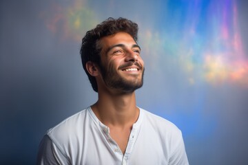 A man with a beard and a white shirt is smiling