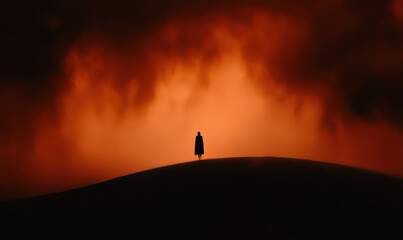 Silhouette on Hill with Fiery Orange and Black Dramatic Sky