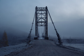 Bridge in the fog. Blue winter background.