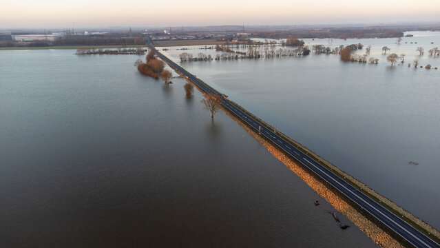 Aerial view of A19 main road on raised embankment above flooded landscape 