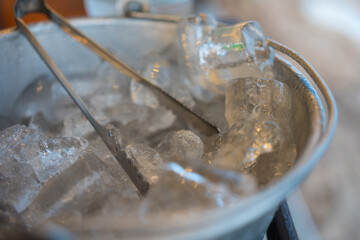 A bucket of ice with a trowel for make water, whisky, vodka or alcohol drinking cold.