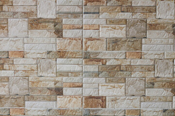 A brick wall with brown and white bricks. The wall is made of stone and has a rustic look