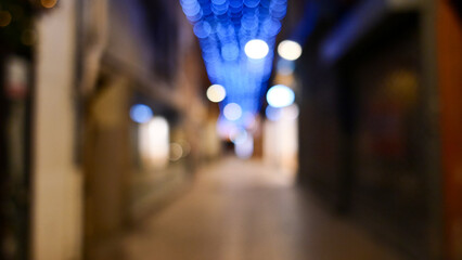 Fototapeta premium Festive garlands out of focus, street decoration, bokeh, night photography, France, Perpignan