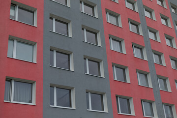 Fototapeta premium A striking red and gray building, featuring an abundant number of windows that provide ample natural light throughout the structure