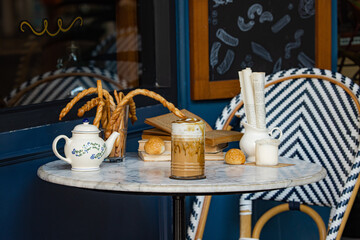 A cozy café setting featuring a marble table with a beverage, pastries, and decorative elements, perfect for a relaxed outing.