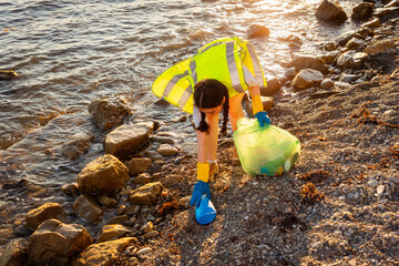 Earth day and environmental conservation. Top view of woman volunteer picking up garbage at beach. Concept of ocean's pollution and recycling garbage