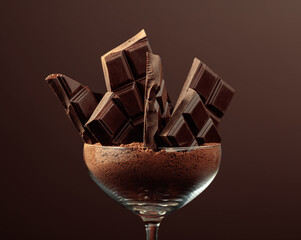 Broken chocolate bar in glass with cocoa powder on a brown background.