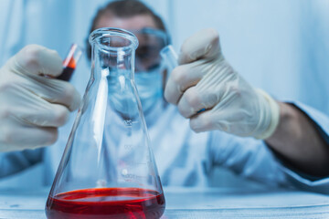 Scientist examining liquid in test tube with lab equipment in laboratory