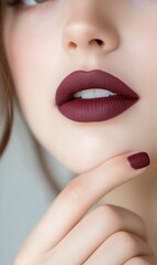 Fototapeta premium Close-up of a woman's lips with bold lipstick and manicured nails.