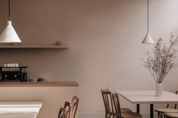 A warm and inviting coffee shop interior featuring minimalist decor and soft lighting. The cozy ambiance is enhanced by natural elements, creating a relaxing and welcoming atmosphere.