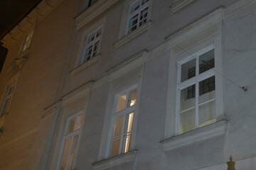 A large building that features numerous windows is beautifully illuminated during the night,...