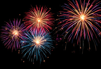 Colorful fireworks display in the night sky, with bursts of red, blue, and gold fireworks against a dark background