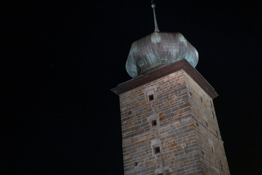 A stunning brick tower, featuring an impressive dome perched on its top, stands majestically at night, illuminated by soft lighting