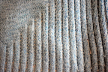 Knitted products, light blue women's woolen sweater with interesting patterns, knitting in the form of a braid, gathered elastic, different weaves and stitching.
