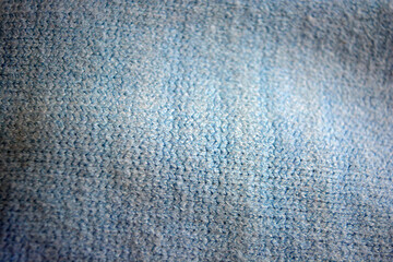 Knitted products, light blue women's woolen sweater with interesting patterns, knitting in the form of a braid, gathered elastic, different weaves and stitching.